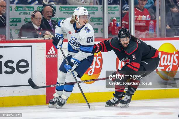 Kyle Connor of the Winnipeg Jets and Jalen Chatfield of the Carolina Hurricanes keep an eye on the play during first period action at the Canada Life...