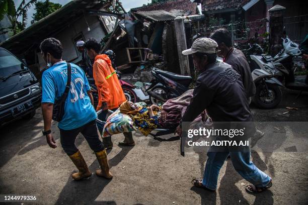 Villagers carry an injured victim following a 5.6-magnitude earthquake that killed at least 162 people, with hundreds injured and others missing in...