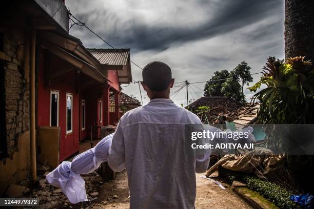 Villager carries the body of his dead son following a 5.6-magnitude earthquake that killed at least 162 people, with hundreds injured and others...