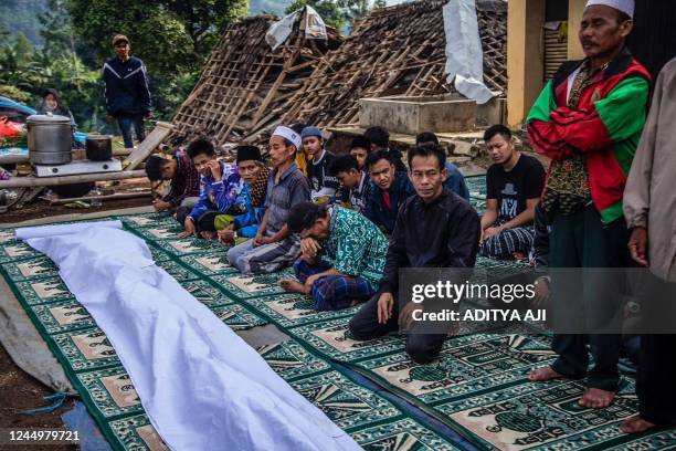 Villagers offer prayers pray during a funeral following a 5.6-magnitude earthquake that killed at least 162 people, with hundreds injured and others...