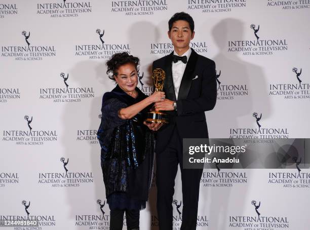 Miky Lee , Vice Chairwoman of CJ Group, poses alongside South Korean actor Song Joong-ki with the International Emmy Directorate Award during the...