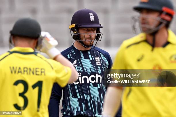 England wicketkeeper Jos Buttler looks on as Australia's David Warner and Travis Head take more runs during the third one-day international cricket...