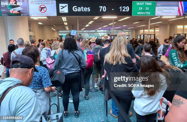 People wait in a TSA screening line at Orlando International Airport three days before Thanksgiving in Orlando, Florida. Airport officials expect...