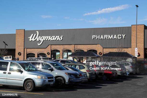 Cars are seen parked in front of a Wegmans supermarket.