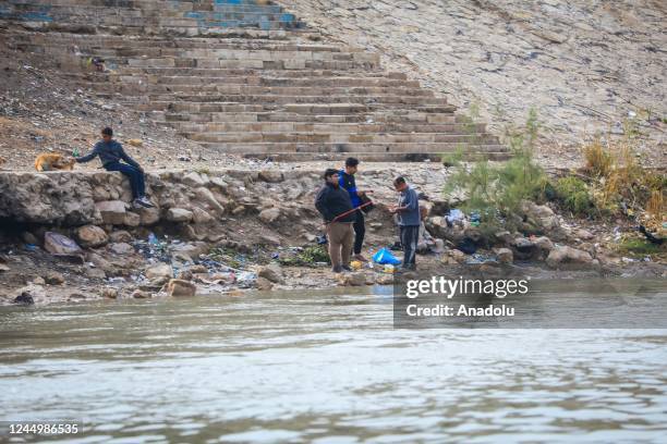 People are seen by the Tigris River, heavily polluted due to chemical waste and garbage dump in Baghdad, Iraq on November 16, 2022. As sewage water;...