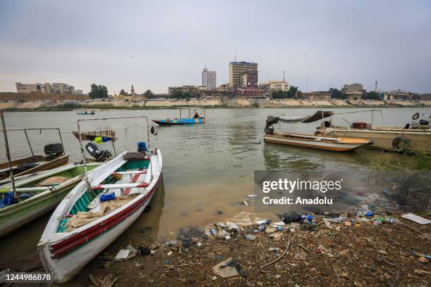 View of boats and trash on Tigris River, heavily polluted due to chemical waste and garbage dump in Baghdad, Iraq on November 16, 2022. As sewage...