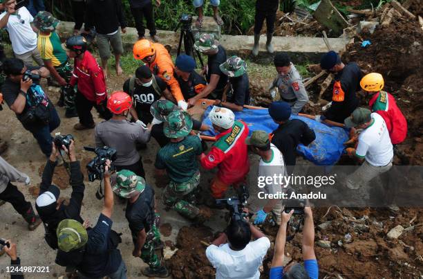 Police and search and rescue officers evacuate the bodies of landslide victims who were buried in the ground due to an earthquake with a magnitude of...