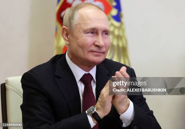 Russian President Vladimir Putin applauses as he attends an online conference in his residence Novo-Ogaryovo outside Moscow on November 22, 2022. -...