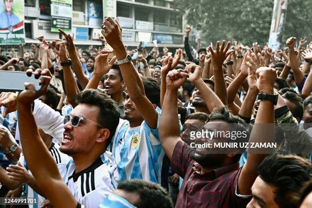 Football fans celebrate after Argentina's Lionel Messi scored a goal as they watch the Qatar 2022 World Cup Group C football match between Argentina...