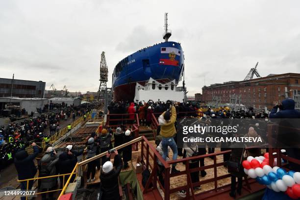 People attend the float out ceremony of the nuclear-powered ice-breaker Yakutia at the Baltic shipyard in Saint Petersburg on November 22 as Russia...