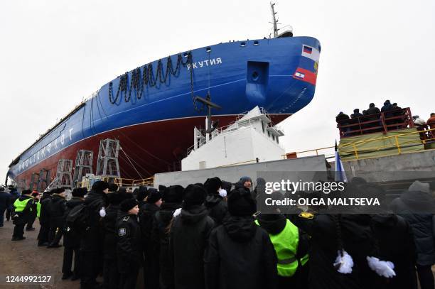 People attend the float out ceremony of the nuclear-powered ice-breaker Yakutia at the Baltic shipyard in Saint Petersburg on November 22 as Russia...