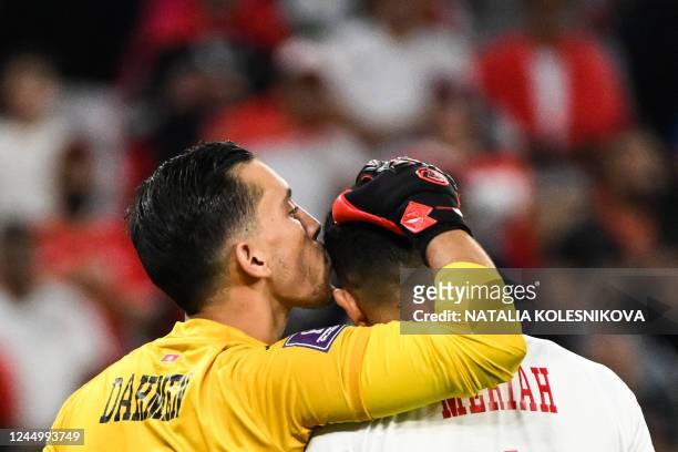 Tunisia's goalkeeper Aymen Dahmen kisses Tunisia's defender Yassine Meriah on the head during the Qatar 2022 World Cup Group D football match between...