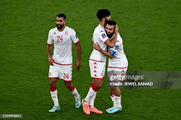 Tunisia's defender Ali Abdi, Tunisia's midfielder Ferjani Sassi and Tunisia's forward Naim Sliti celebrate their draw after the Qatar 2022 World Cup...