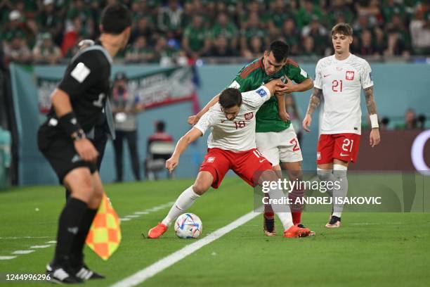 Poland's defender Bartosz Bereszynski fights for the ball with Mexico's defender Nestor Araujo during the Qatar 2022 World Cup Group C football match...