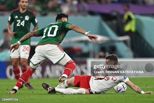 Mexico's forward Alexis Vega and Poland's midfielder Sebastian Szymanski fight for the ball during the Qatar 2022 World Cup Group C football match...