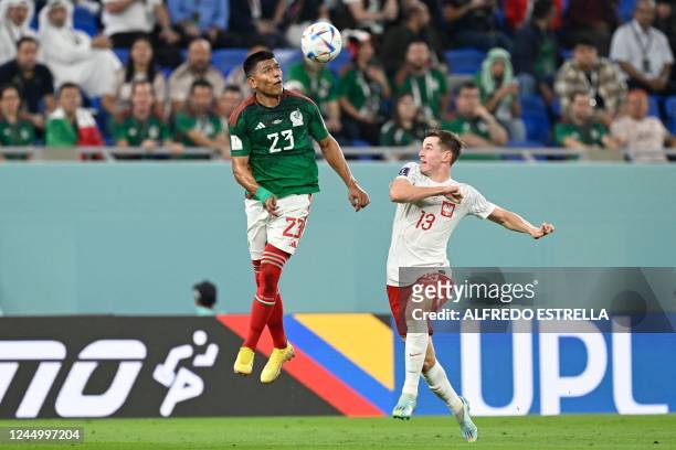 Mexico's defender Jesus Gallardo heads the ball past Poland's midfielder Jakub Kaminski during the Qatar 2022 World Cup Group C football match...