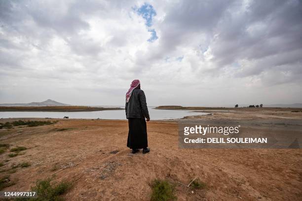 Syrian man walks amidst drought and low water levels in the Euphrates River, in the western countryside of Tabqa in Syria's Raqqa governorate, on...