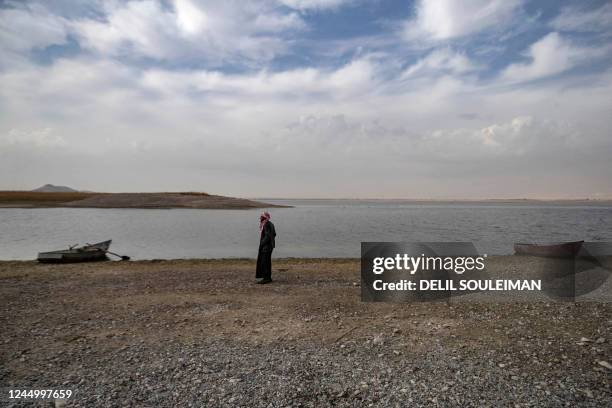 Syrian man walks amidst drought and low water levels in the Euphrates River, in the western countryside of Tabqa in Syria's Raqqa governorate, on...