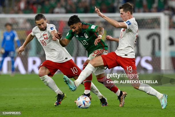 Mexico's forward Alexis Vega fights for the ball with Poland's midfielder Grzegorz Krychowiak and Poland's midfielder Jakub Kaminski during the Qatar...