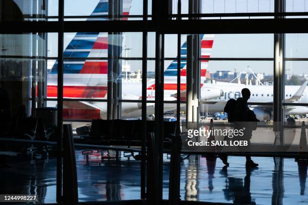American Airlines airplanes are seen past a traveler walking through Ronald Reagan Washington National Airport in Arlington, Virginia, on November 22...