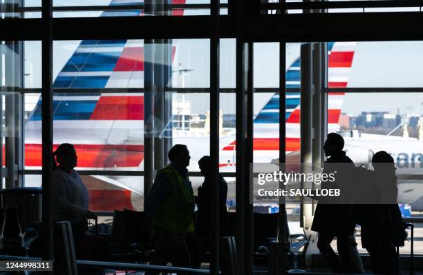 American Airlines airplanes are seen past travelers walking through Ronald Reagan Washington National Airport in Arlington, Virginia, on November 22...