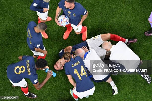 France's defender Lucas Hernandez receives medical treatment during the Qatar 2022 World Cup Group D football match between France and Australia at...