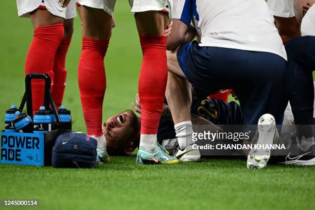 France's defender Lucas Hernandez lies on the pitch after he sustained an injury during the Qatar 2022 World Cup Group D football match between...