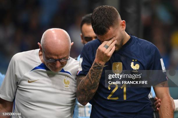 France's defender Lucas Hernandez reacts as he leaves the pitch after he sustained an injury during the Qatar 2022 World Cup Group D football match...