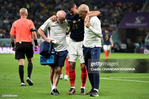 France's defender Lucas Hernandez leaves the pitch after sustaining an injury during the Qatar 2022 World Cup Group D football match between France...