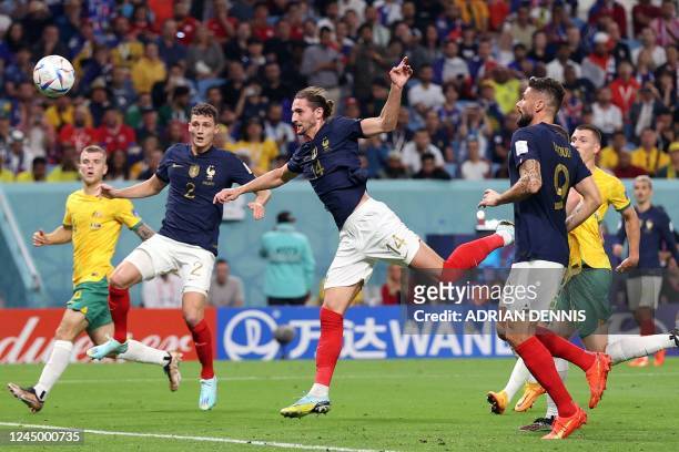 France's midfielder Adrien Rabiot heads the ball to score his team's first goal during the Qatar 2022 World Cup Group D football match between France...