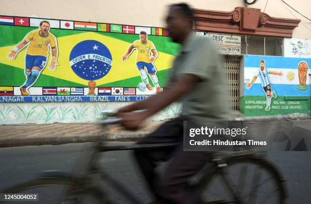 People walk past wall graffiti of football players Neymar, Vinicius Jr. And Messi to celebrate Qatar World Cup 2022 at Gopalnagar on November 22,...
