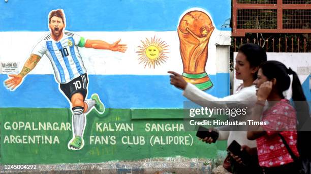 People walk past wall graffiti of Argentina football player Lionel Messi to celebrate Qatar World Cup 2022 at Gopalnagar on November 22, 2022 in...