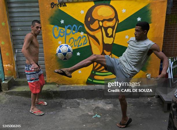 Residents play football in a street in Rocinha favela, Rio de Janeiro, Brazil, on November 22, 2022.