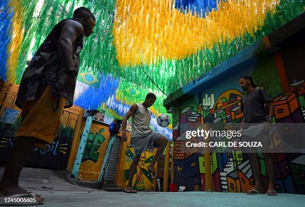 Residents play football in a street in Rocinha favela, Rio de Janeiro, Brazil, on November 22, 2022.