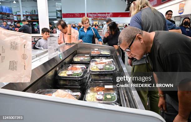 People shop for food items, including portioned turkey dinners, at a Costco store in Monterey Park, California on November 22, 2022. Inflation in the...