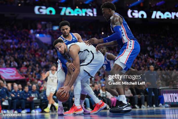 Ben Simmons of the Brooklyn Nets controls the ball against Tobias Harris and Paul Reed of the Philadelphia 76ers in the fourth quarter of the game at...