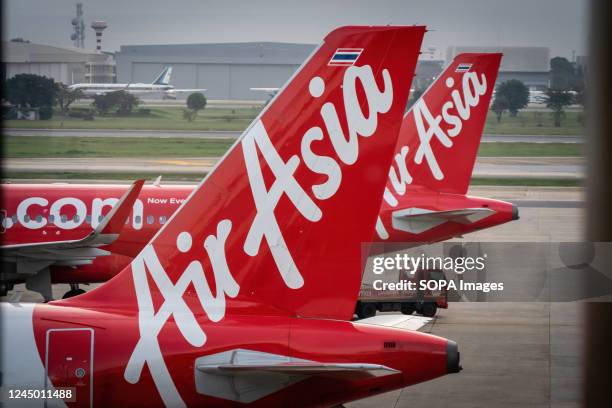 The tails of Thai AirAsia Airbus A320-200 commercial passenger planes are seen while parked at the international departures terminal at Don Mueang...