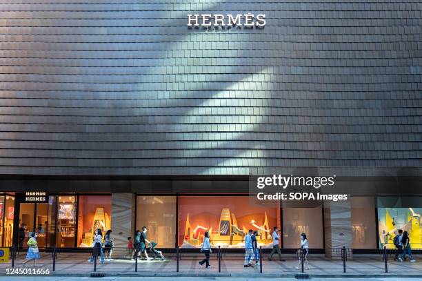 Pedestrians walk past the French high fashion luxury clothing manufacturer Hermes store in Hong Kong.