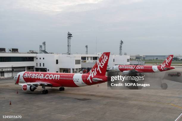 Thai AirAsia Airbus A320-200 commercial passenger planes are seen parked at the international departures terminal at Don Mueang International Airport...