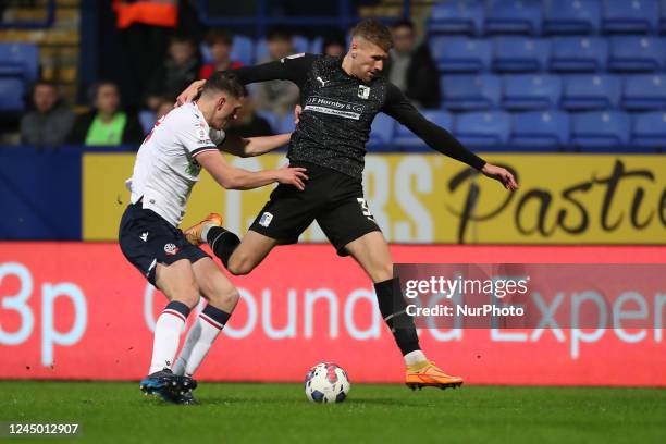 Barrow's Patrick Brough battles with Bolton Wanderers' Josh Sheehan during the EFL Trophy Round of 32 match between Bolton Wanderers and Barrow at...