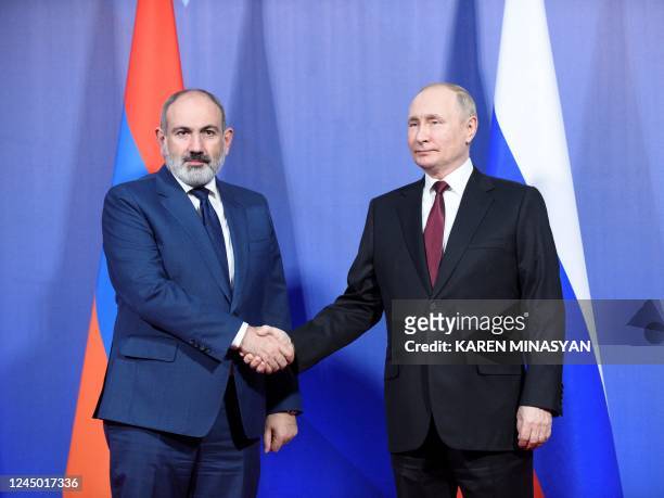 Russian President Vladimir Putin shakes hands with Armenian Prime Minister Nikol Pashynyan during their meeting ahead of the Collective Security...