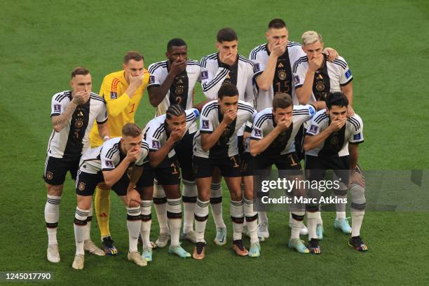 Germany players cover their mouths as they pose for a team photo during the FIFA World Cup Qatar 2022 Group E match between Germany and Japan at...
