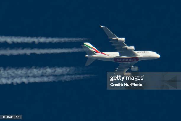 Emirates Airbus A380 double decker passenger aircraft as seen flying in the blue sky over the Netherlands in Europe, the route EK22 from Manchester...