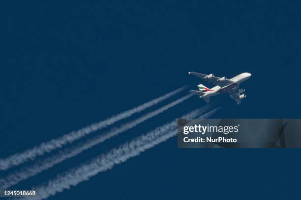 Emirates Airbus A380 double decker passenger aircraft as seen flying in the blue sky over the Netherlands in Europe, the route EK22 from Manchester...