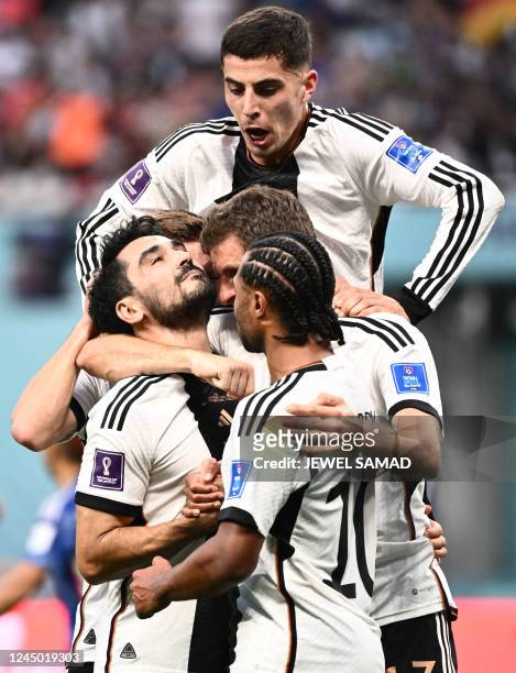Germany's midfielder Ilkay Gundogan celebrates with teammates after scoring his team's first goal from the penalty spot during the Qatar 2022 World...