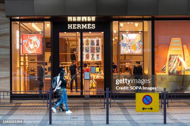 Pedestrians walk past the French high fashion luxury clothing manufacturer Hermes store in Hong Kong.