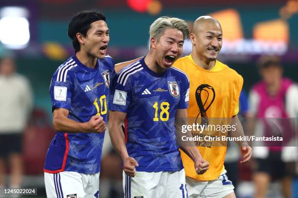 Takumi Minamino, Takuma Asano and Daizen Maeda of Japan celebrate at the end of the FIFA World Cup Qatar 2022 Group E match between Germany and Japan...
