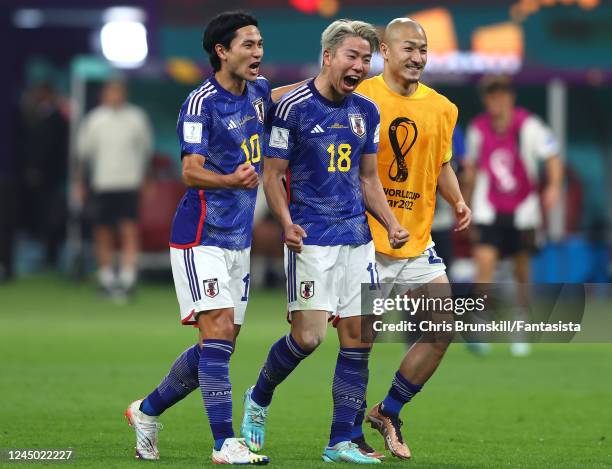 Takumi Minamino, Takuma Asano and Daizen Maeda of Japan celebrate at the end of the FIFA World Cup Qatar 2022 Group E match between Germany and Japan...