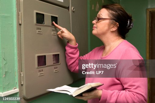 Woman looking electric meter data Woman looking electric meter data