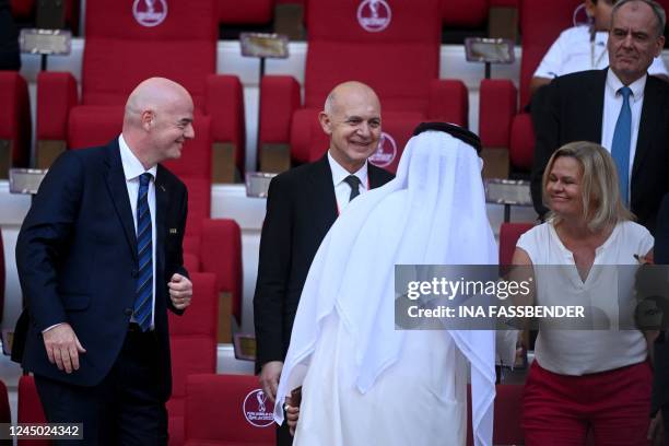 German Interior Minister Nancy Faeser wearing an One Love armband shakes hands with an official next to the president of the German Football...